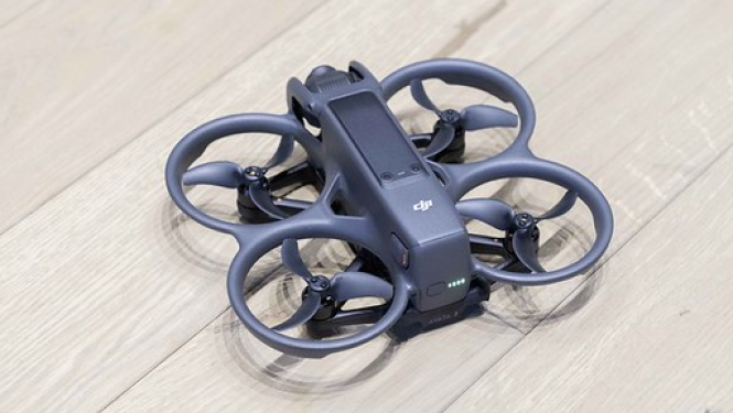 Bezpilota lidaparāts, jeb drons. Atrodas miera stāvoklī uz grīdas.