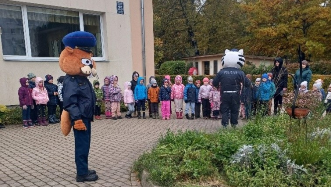 Zvēru maskās tērpti Valsts policijas pārstāvji bērnudārza pagalmā tiekas ar bērniem