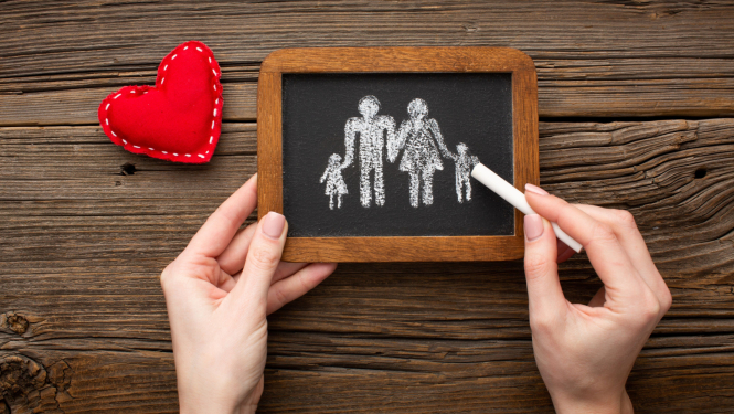 Ar krītu uz tāfelītes zīmēta ģimene. Attēls rakstam ar aicinājumu piedalītie audžuģimeņu apmācībās.