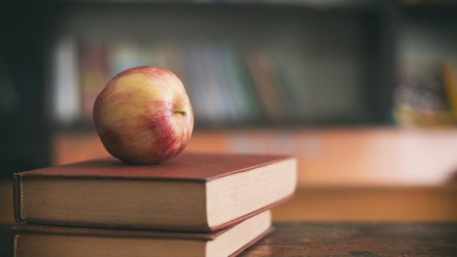 Iespēja pieteikties sociālajai stipendija vidusskolēniem. Attēlā grāmatas un ābols uz tām.