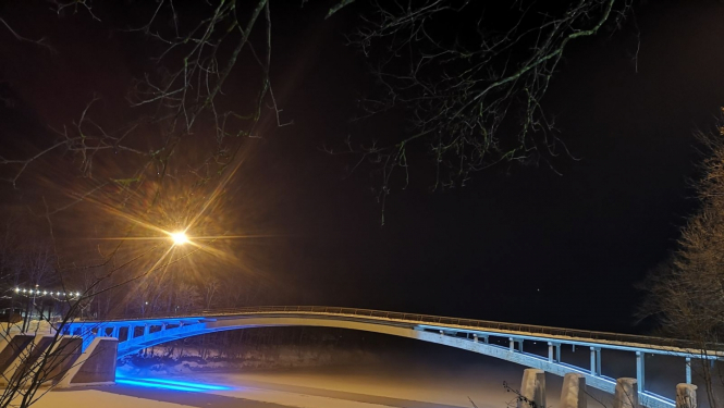 Igaunijas karoga krāsās izgaismots lokveida gājēju tilts