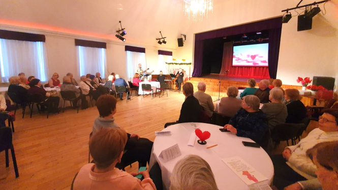 Pasākums Paaudžu satikšanās romantiskās noskaņās Ikšķiles Tautas namā - pilna zāle ar cilvēkiem