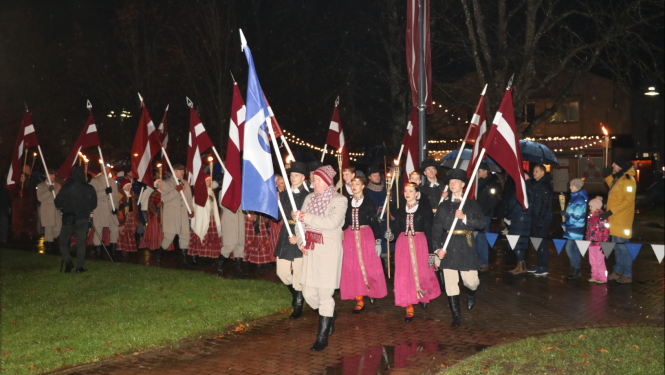 Gājiena dalībnieki ierodas pie monumentālā Latvijas karoga