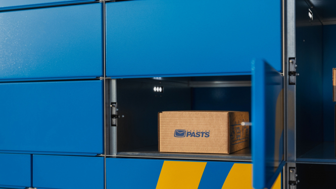 Latvijas pasta pakomāts ar atvērtām nodalījuma durtiņām un ievietotu kartona kasti