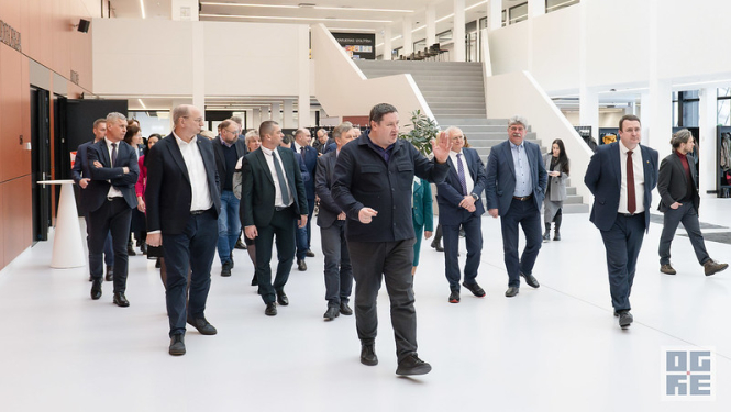Egils Helmanis Ogres Valsts ģimnāzijas foajē iepazīstina pašvaldību vadītājus ar skolu