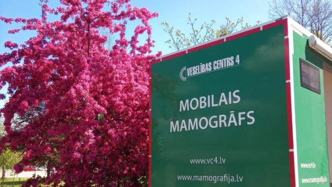 Mobilā mamogrāfa automobilis pie ziedoša koka
