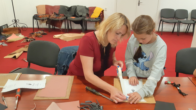 Vecāki kopā ar bērniem radoši darbojas pastalu darināšanas darbnīcā