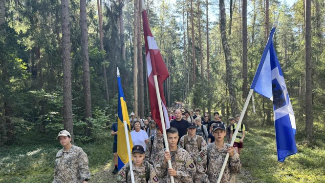 Vīrieši zemessardzes tērpos nes Latvijas, Ukrainas un Ogres novada karogus 06.09.2024.