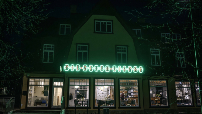 Ēka ar mirdzošu uzrakstu ar "Pie Zelta liepas"