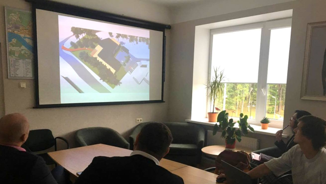 Sanāksmes dalībnieki skatās prezentāciju