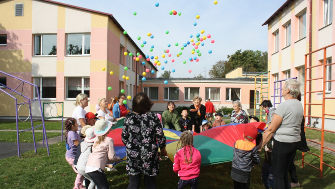 Bērni ar senioriem uz liela auduma met bumbas 09.2024.