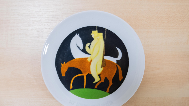 Porcelāna šķīvis ar Romana Sutas mākslas darba "Div' dūjiņas" reprodukciju 