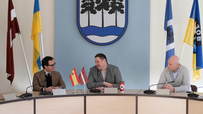 Spānijas vēstnieks Manuels Alams Oreness, domes priekšsēdētājs Egils Helmanis un viņa vietnieks Gints Sīviņš sarunājas, sēžot pie galda domes sēžu zālē