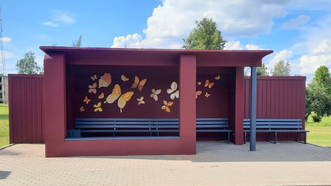 Autobusu pietura Taurupē, violeti-rozā krāsā, apgleznota ar taureņiem 08.20214.