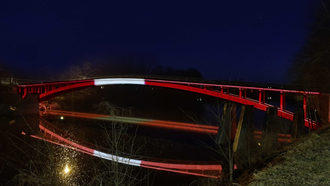 Tilts pār Ogres upi izgaismots Latvijas karoga krāsās