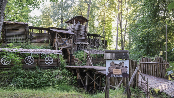 Uldevenes pils Lielvārdē 2024. gada pavasarī zaļu koku ielenkumā