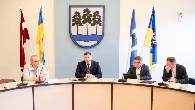 Egils Helmanis, Indulis Trapiņš un Latvijas Valsts ceļu pārstāvji sēž pie galda domes sēžu zālē