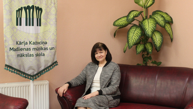 Kārļa Kažociņa Madlienas Mūzikas un mākslas skolas direktore Vita Ervalde sēž pie skolas karoga 11.2023
