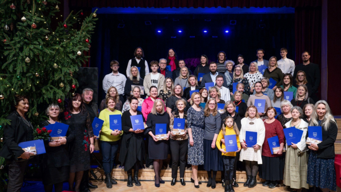 Projektu koordinatoru kopbilde uz kulturas nama skatuves pie izrotātas Ziemassvētku egles