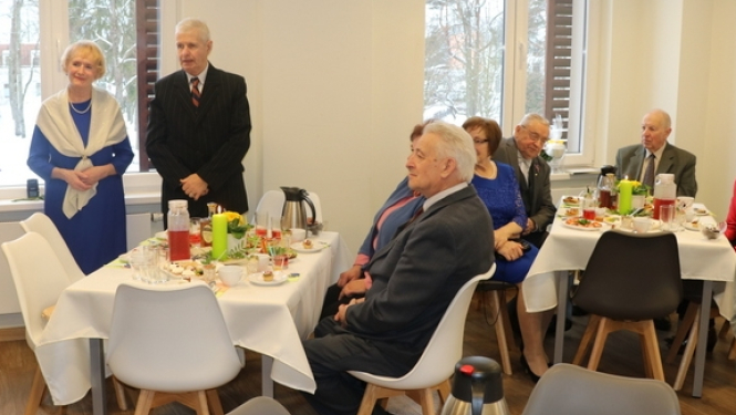 Tiek sveikti Zelta un dimanta pāri - cilvēki pie galda, svinīgos tērpos