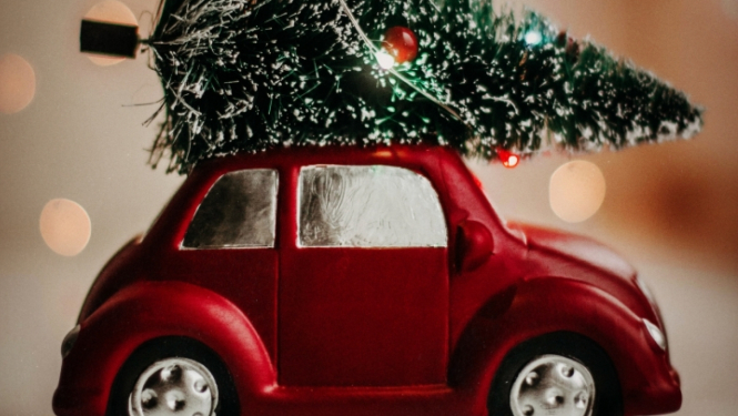 Ziemassvētku egle uz sarkanas mašīnas
