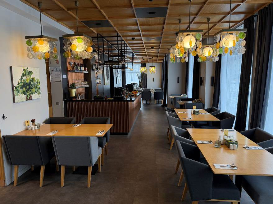 Kafejnīcas zāle ar galdiem un krēsliem