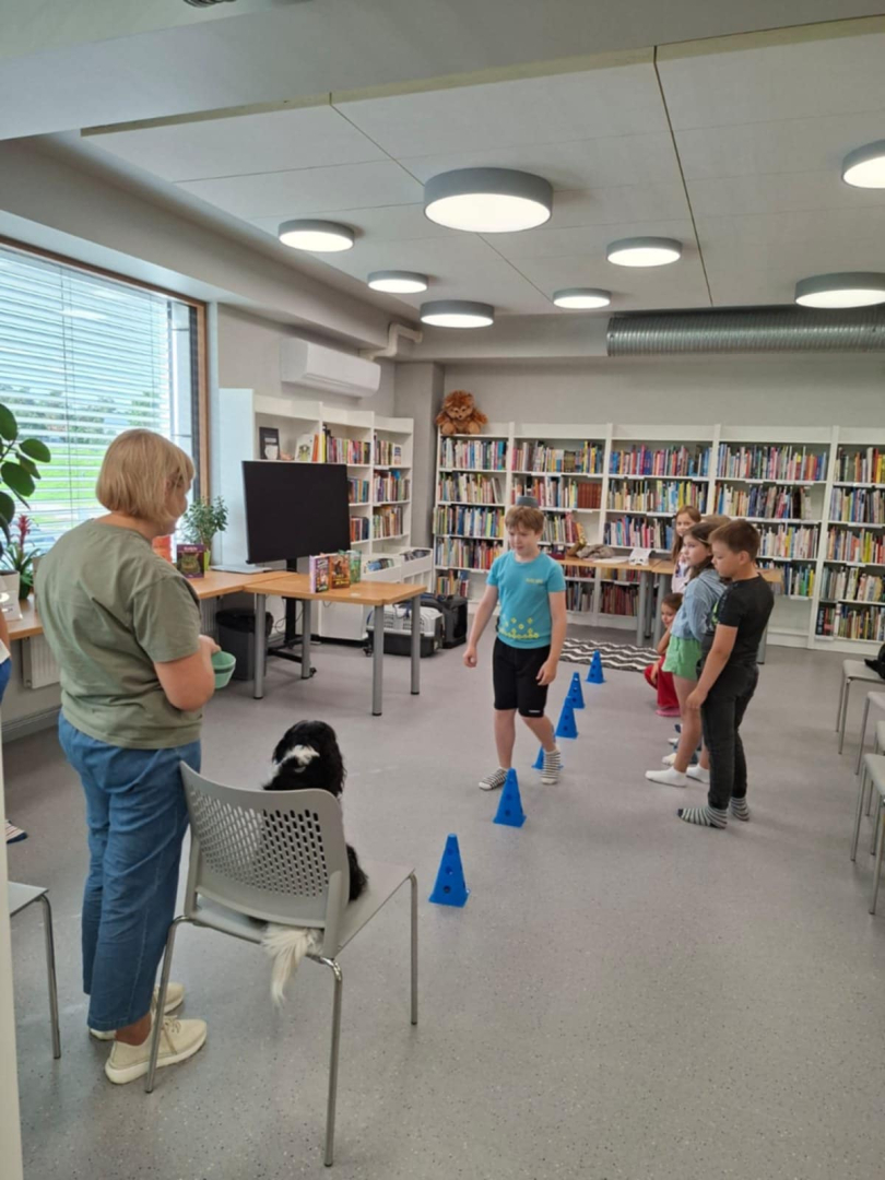 Ikšķiles pilsētas bibliotēkā realizēts neparasts projekts – ar kanisterapijas palīdzību veicināts bērnu lasītprieks. Bērni iesaistās spēlē ar suni