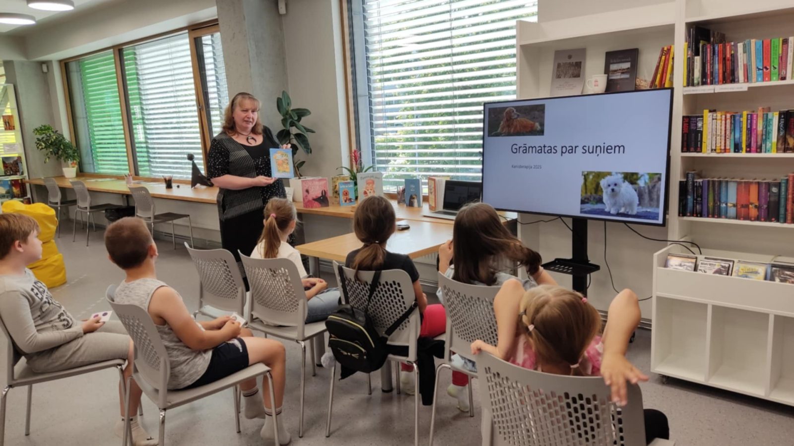 Ikšķiles pilsētas bibliotēkā realizēts neparasts projekts – ar kanisterapijas palīdzību veicināts bērnu lasītprieks. Bērni klausās stāstītajā