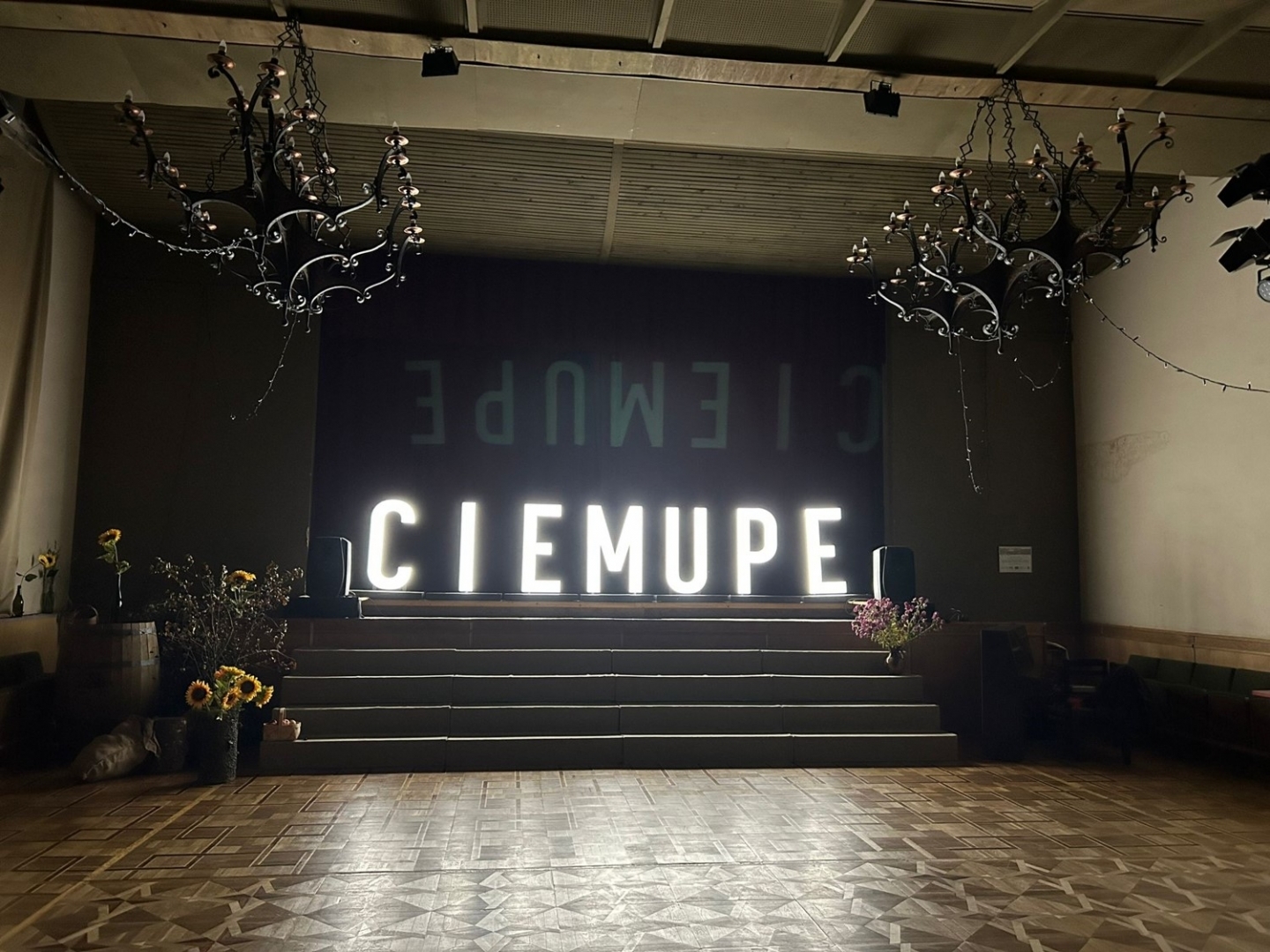 Izgaismots uzraksts "Ciemupe" Ciemupes Tuatas nama zālē uz skatuves