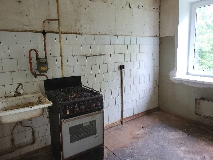 Tukša virtuves telpa ar izlietni un gāzes plīti