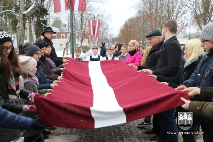 Skolēni godina Latvijas karogu