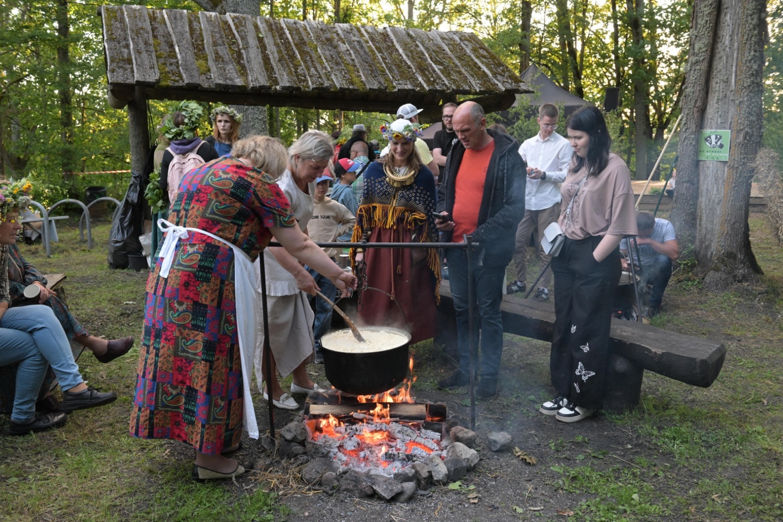 Cilvēki uz ugunskura lielā katla  varā putru Plāteres pilskalnā 20.06.2024.