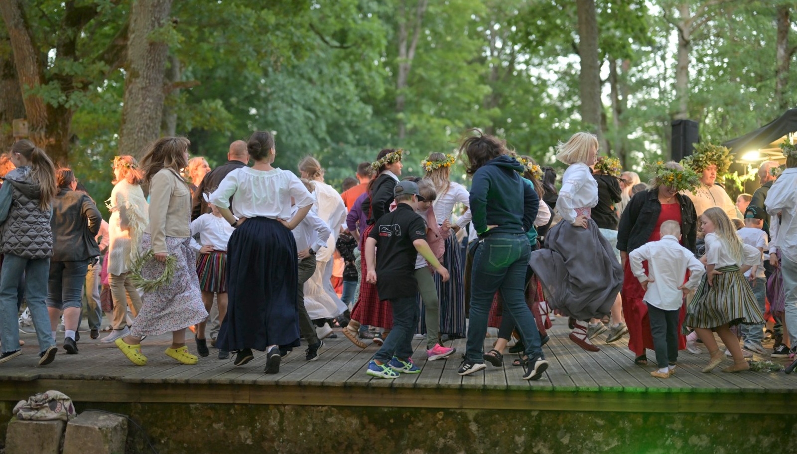 Cilvēki dejo uz skatuves tautiskas dejas Plāteres pilskalnā 20.06.2024.
