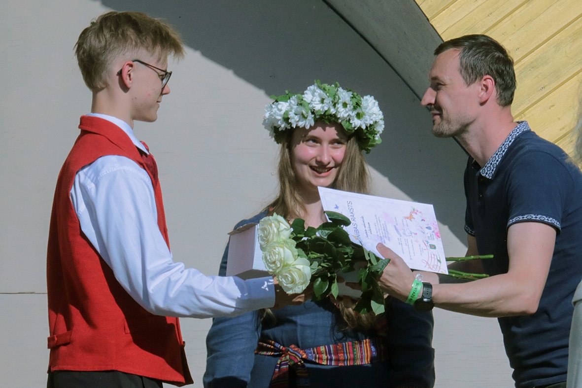 Pasniedz pateicības rakstu zēnam pasākumā Sadziedāsim Suntažos! 24.05.2024.