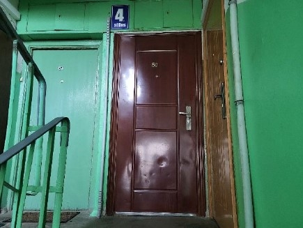 Zaļas sienas, kāpnes, brūnas durvis