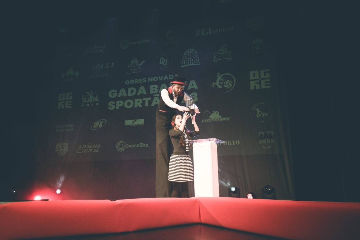 Gada balvas sportā 2023 pasākums cilv'kes uz koka kājām un jauna meitene pie sporta balvas 16.02.2024