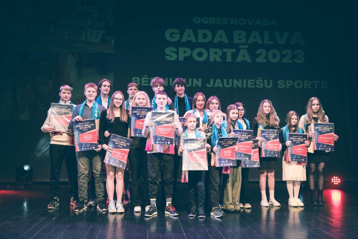 Gada balvas sportā 2023 jauniešu kopbilde ar kalendāriem, fona pasākuma plakāts 16.02.2024. 