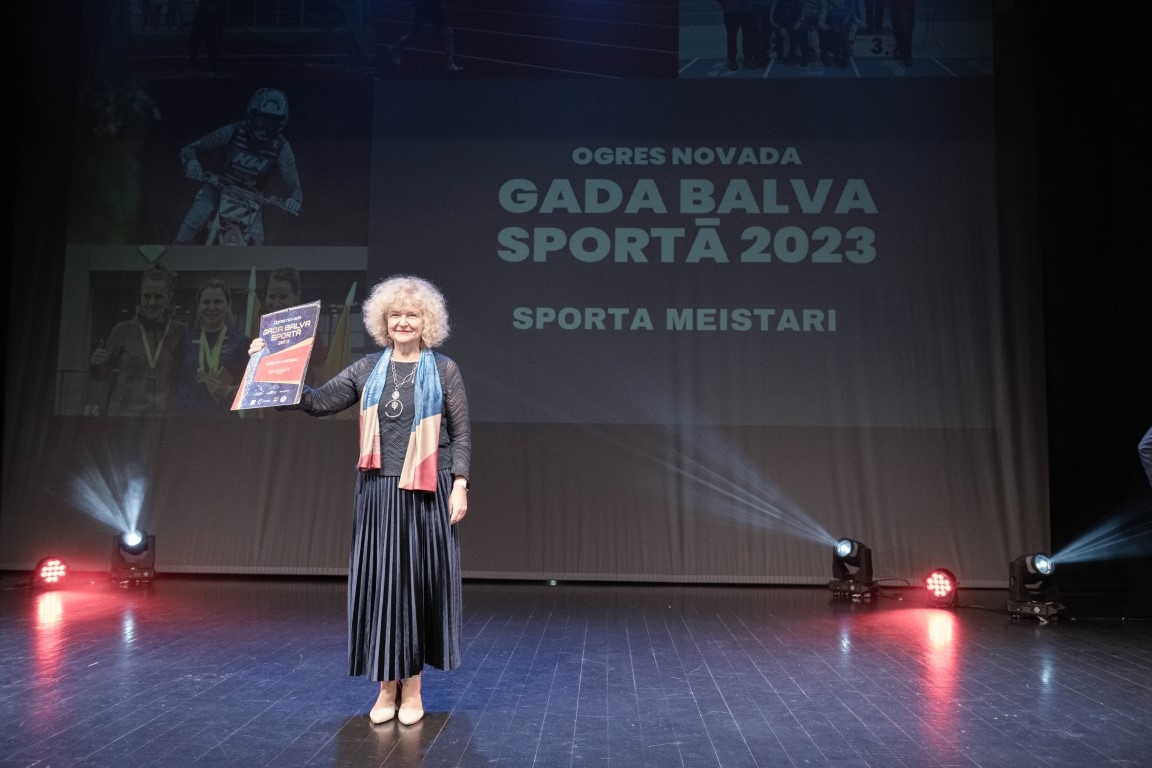 Sporta gada balva: sieviete trenere melnā tērpā ar kalendāru 16.02.2024