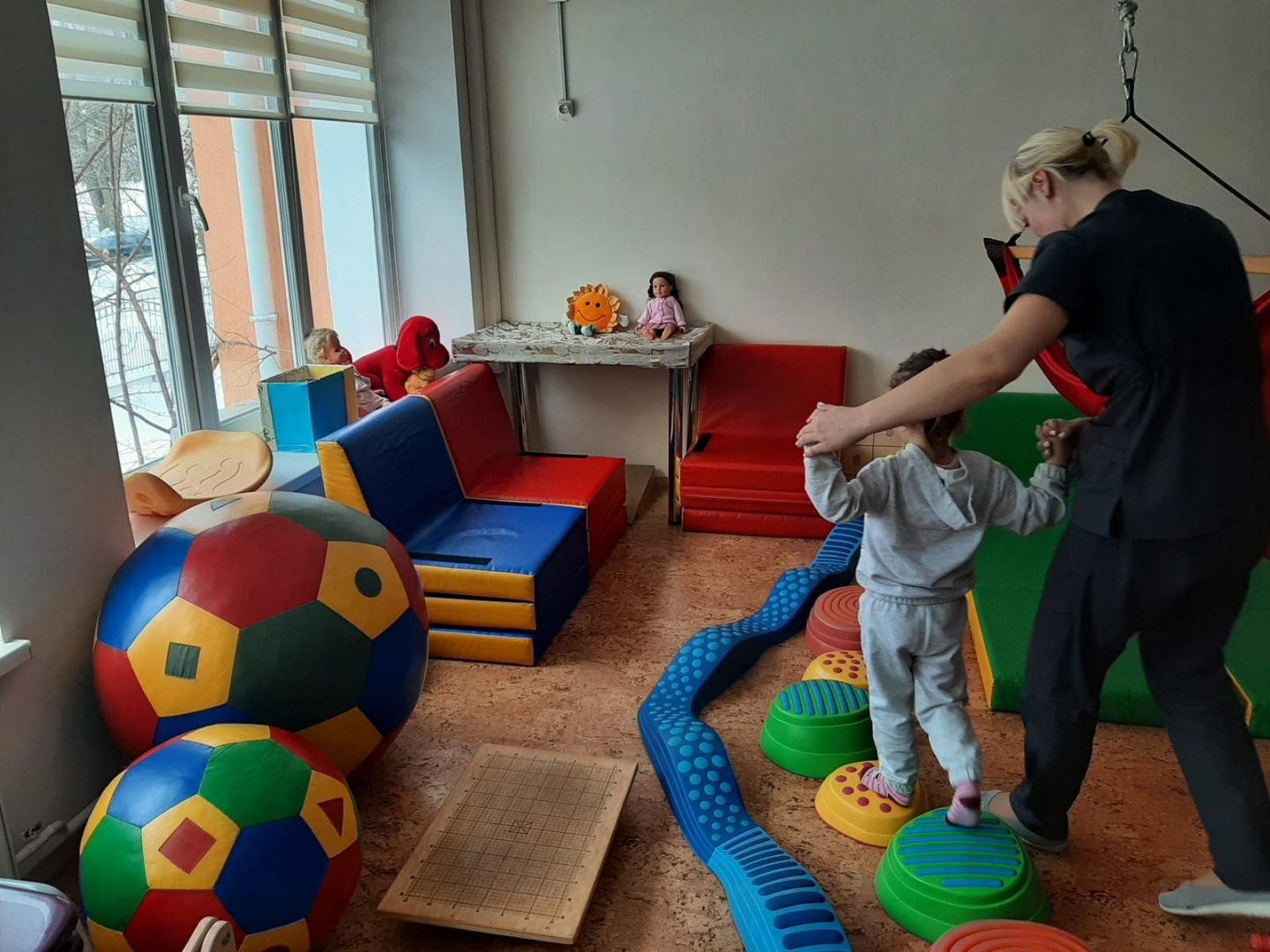 Ukrainas rehabilitācijas centrs bērniem ar īpašām vajadzībām “Atdzimšana”, bērns staigā pa bumbām, vingrošanas telpa. 12.2023.  