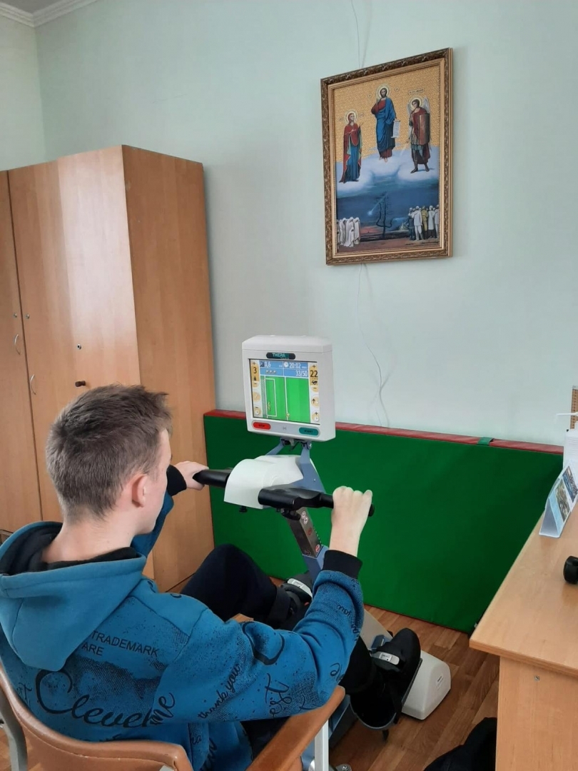 Ukrainas rehabilitācijas centrs bērniem ar īpašām vajadzībām “Atdzimšana”, jaunietis pie trenažiera 12.2023.