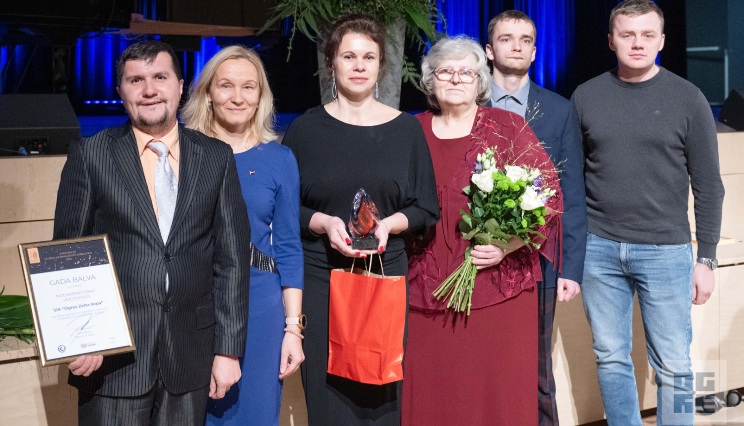 Kafejnīcas “Pie Zelta Liepas” seši pārstāvji ar saņemto Gada balvu un ziediem