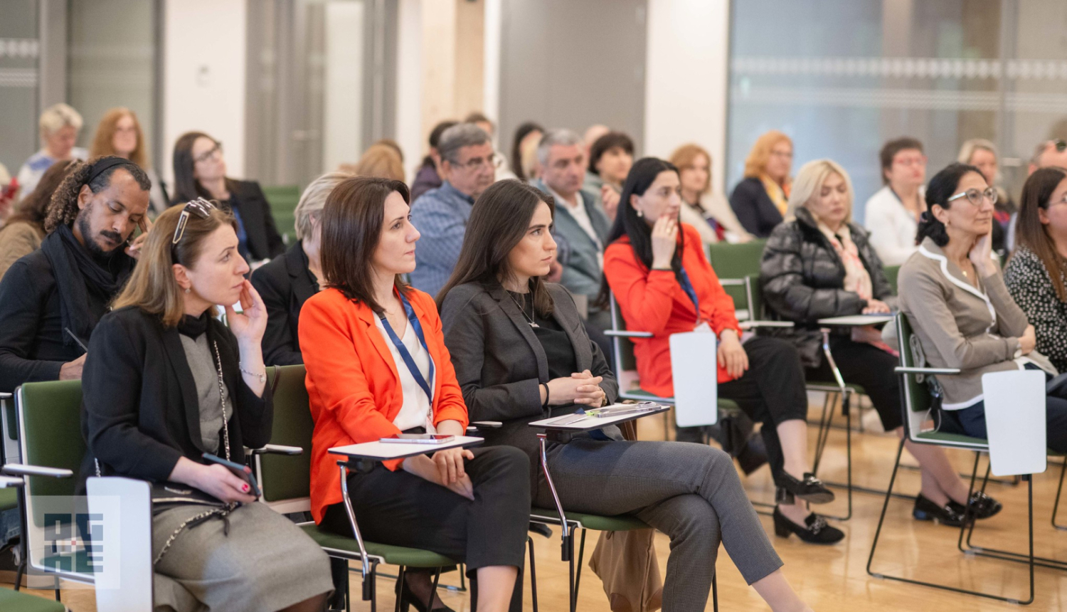 Mācību vizītes dalībnieki klausās prezentāciju Ogres Centrālās bibliotēkas zālē