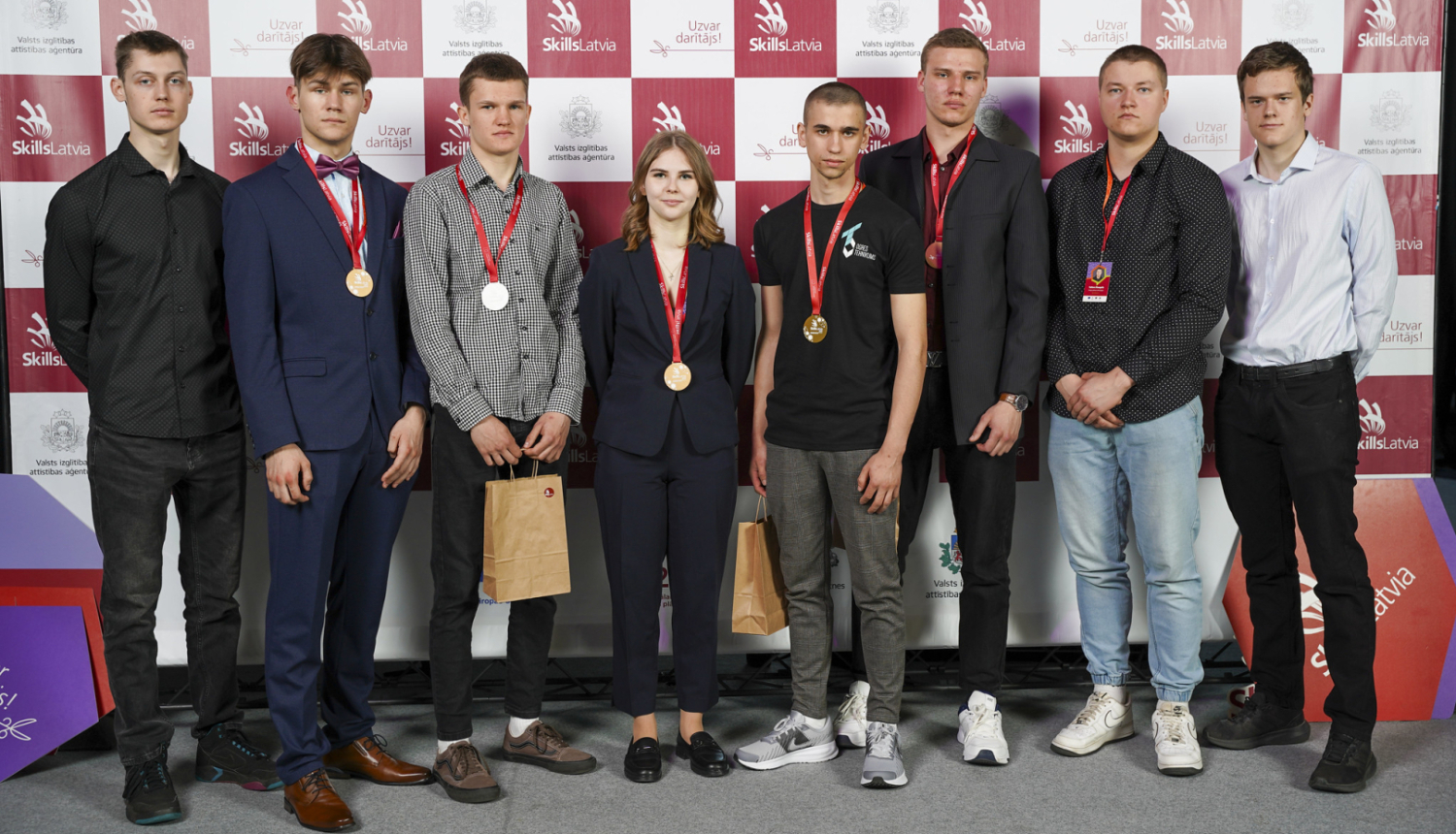 Astoņu Ogres tehnikuma audzēkņu kopbilde "Skills Latvia" fotostendā