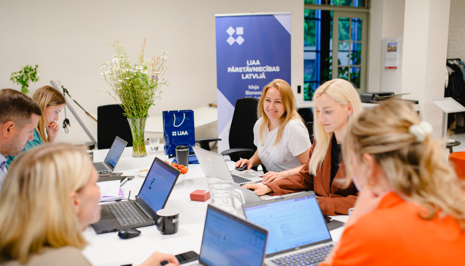 Latvijas Investīciju un attīstības aģentūras inkubācijas programmas rudens uzņemšana. Attēlā vairāki uzņēmēji ar atvērtiem planšetdatoriem, smaidīgi