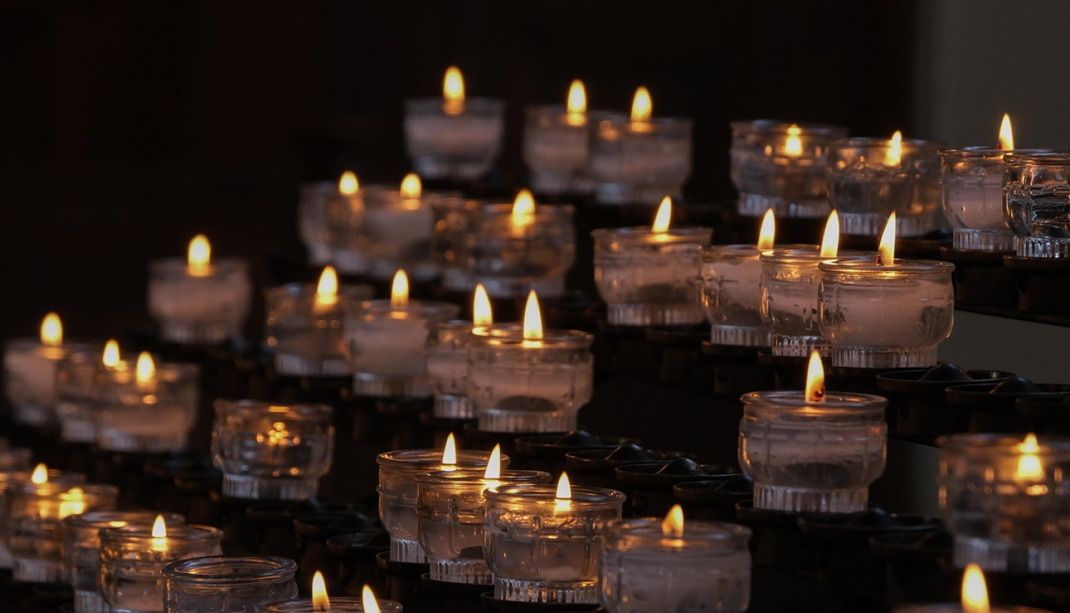 Aizdedzinātas svecītes, saliktas rindiņā.