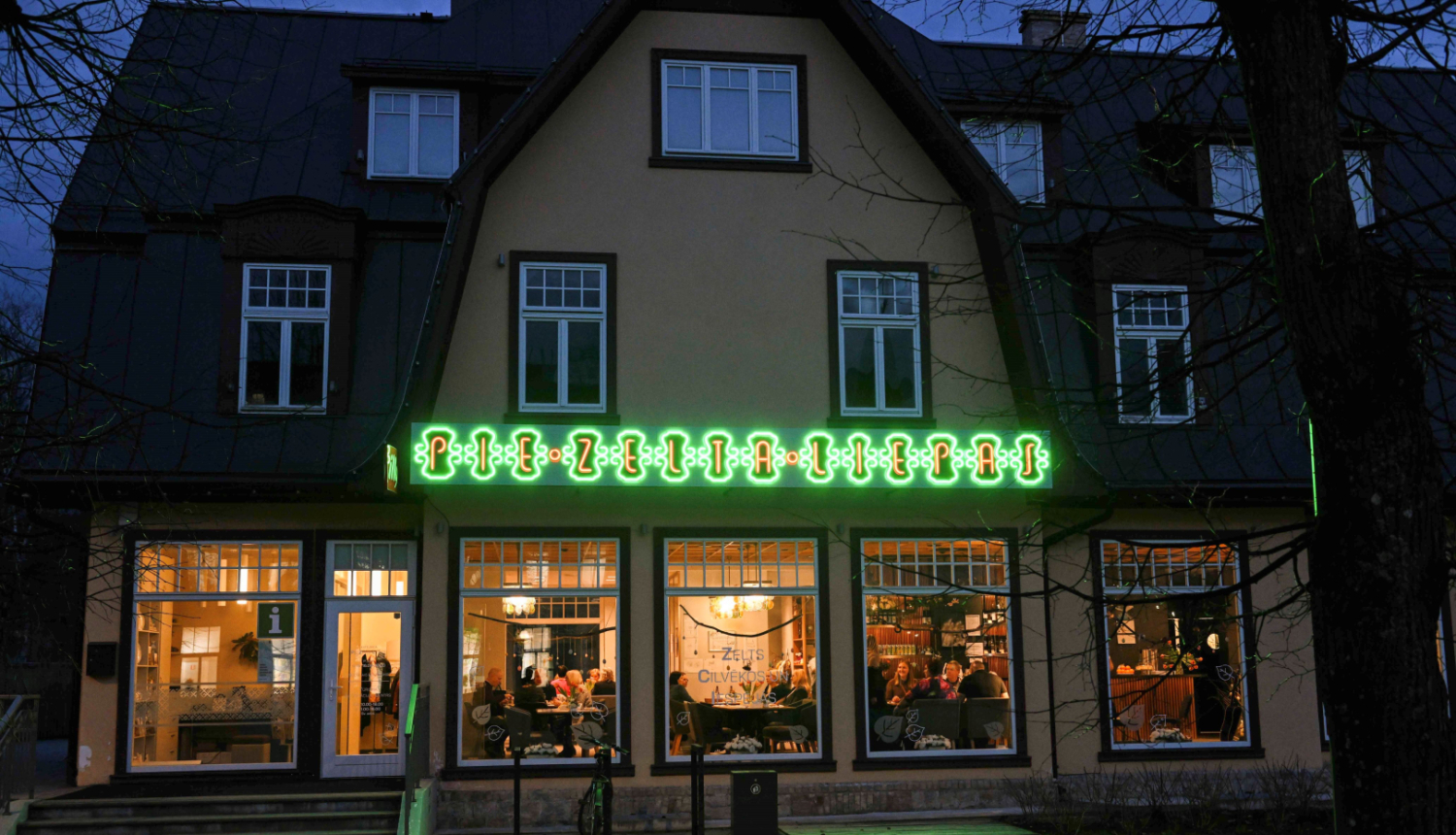 Pie Zelta Liepas - kafejnīca mijkrēslī, degot neona uzrakstam