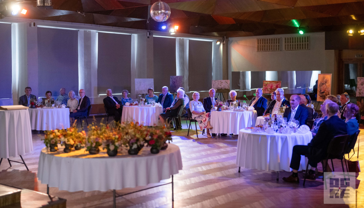 7. jūnijā Ogres novada Kultūras centrā svinīgā gaisotnē notika Ogres novada stipro pāru godināšanas pasākums – tika sveikti pāri, kuri laulībā nodzīvojuši 50 un 60 gadus. Priekšplānā galds ar īpaši darinātiem māla traukiem katram pārim. Pāri sēž pie galdiņiem un bauda sveikšanas pasākumu.