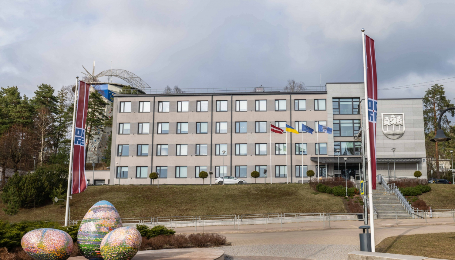 Domes ēka ar Lieldienu rotājumiem priekšplānā