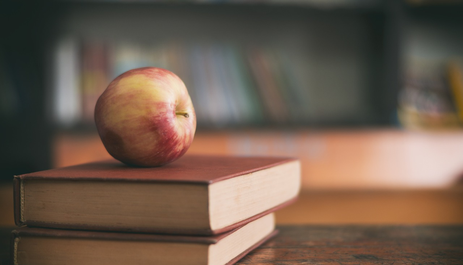 Iespēja pieteikties sociālajai stipendija vidusskolēniem. Attēlā grāmatas un ābols uz tām.