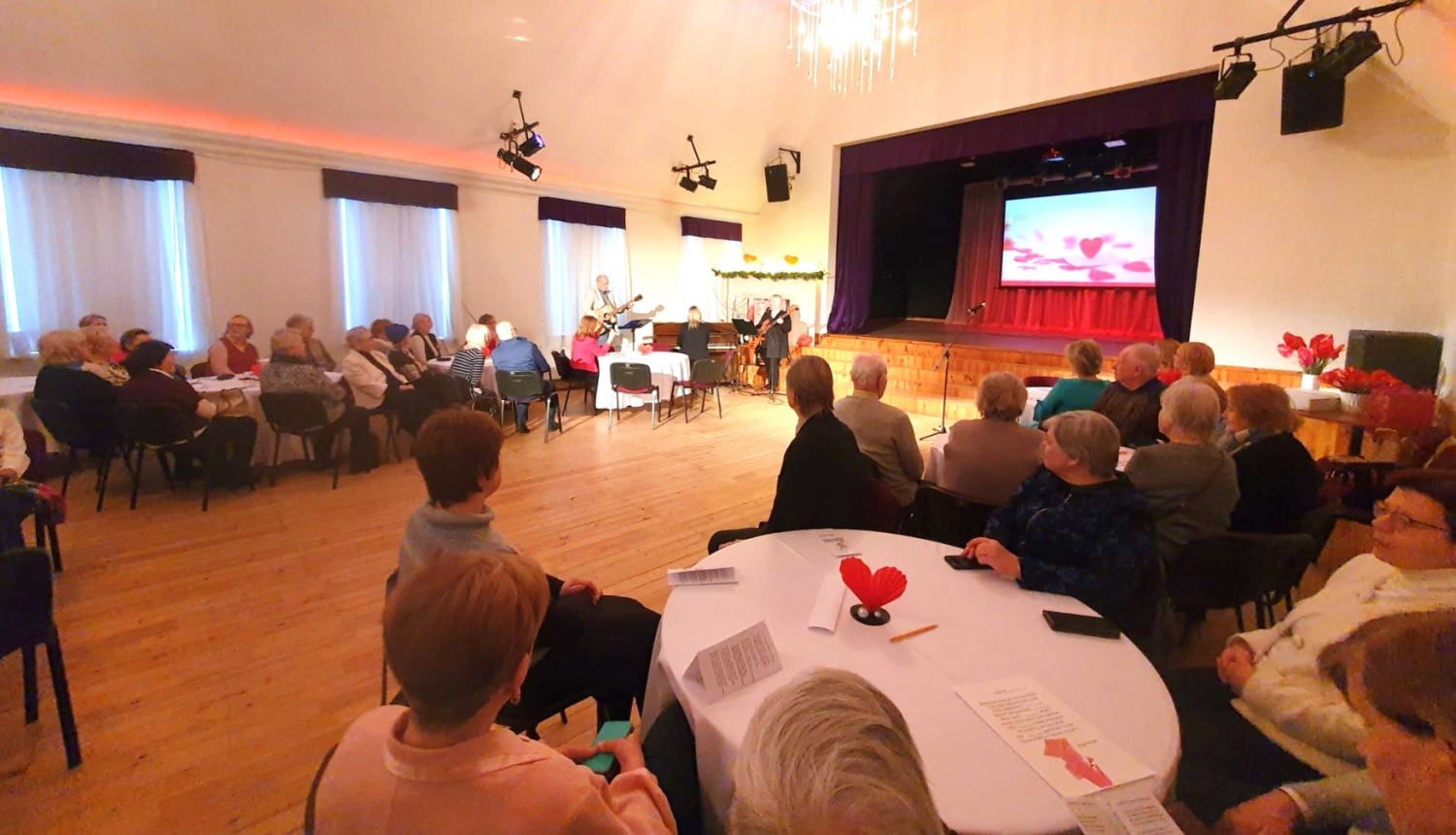 Pasākums Paaudžu satikšanās romantiskās noskaņās Ikšķiles Tautas namā - pilna zāle ar cilvēkiem